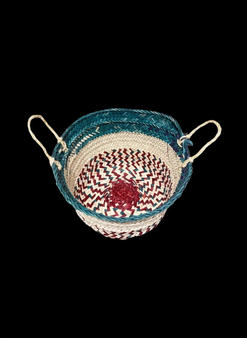 Small palm-leaf basket with a green rim and maroon base — top view